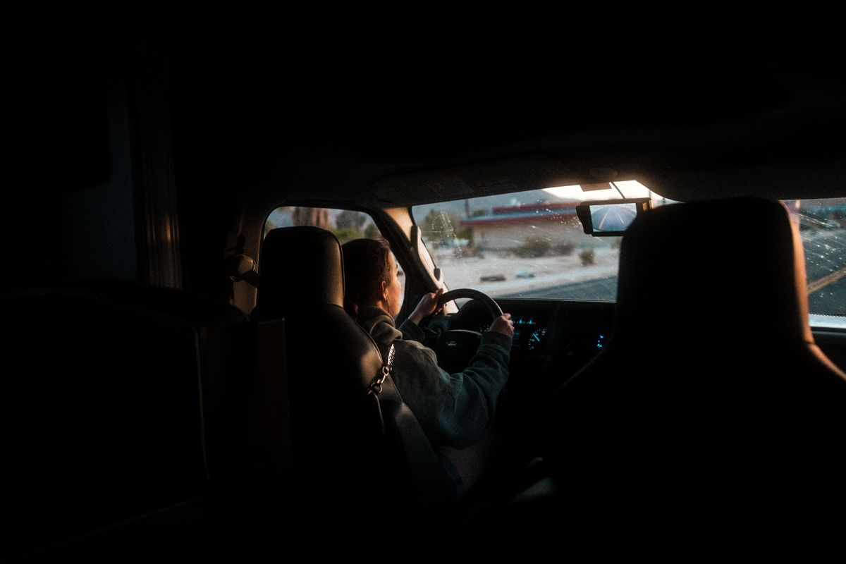 A woman driving a car through California at twilight, interior view