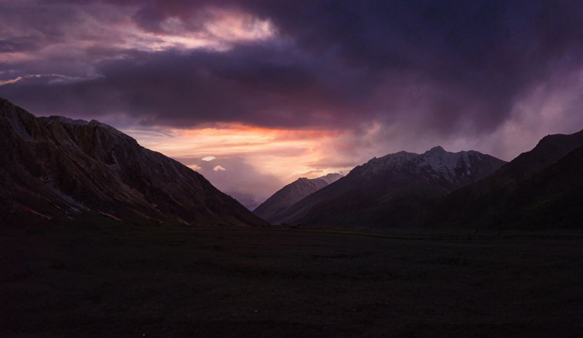 A breathtaking mountain landscape at sunset with dramatic storm clouds