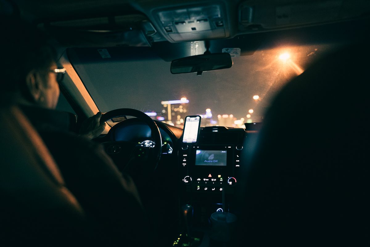 Man in glasses driving car at night