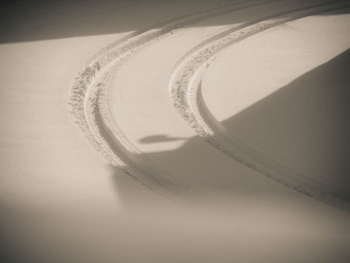 Curved tire tracks on fresh snow in Reggio Emilia, Italy during winter