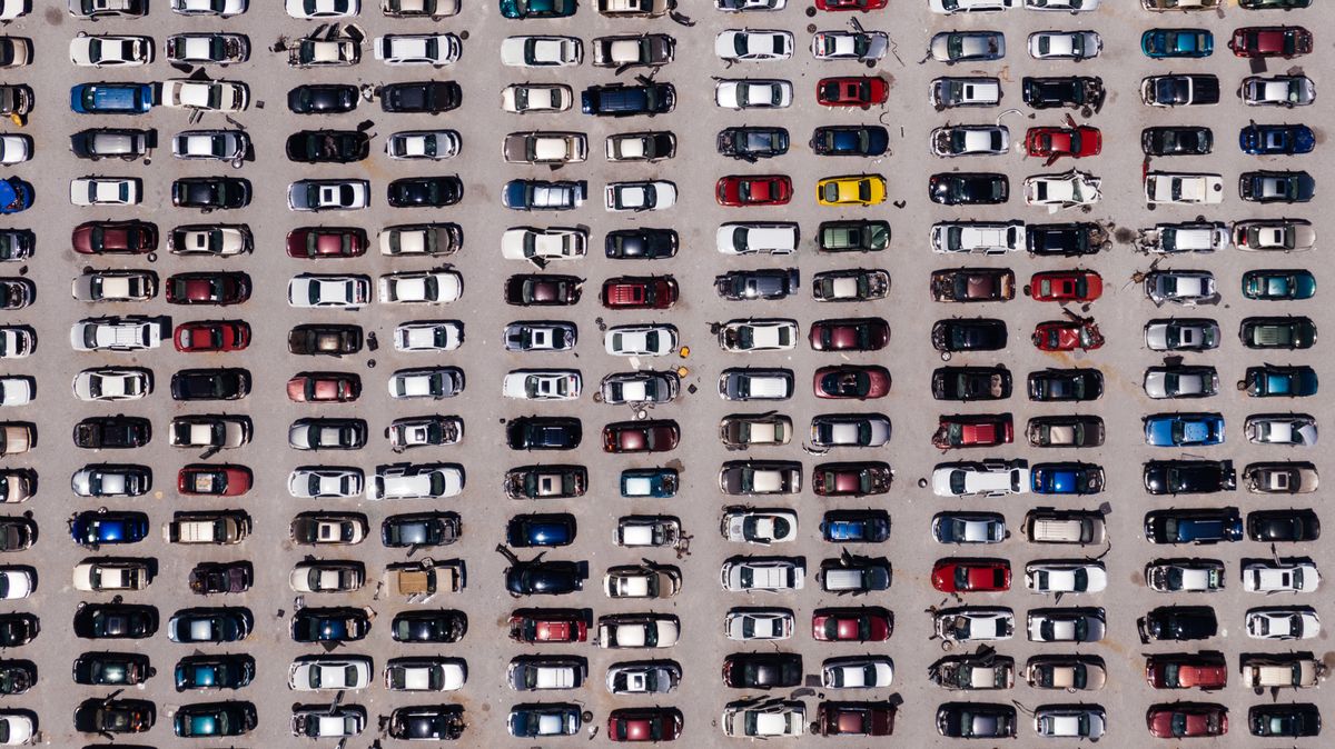 Top-down aerial shot of a large parking lot filled with rows of cars