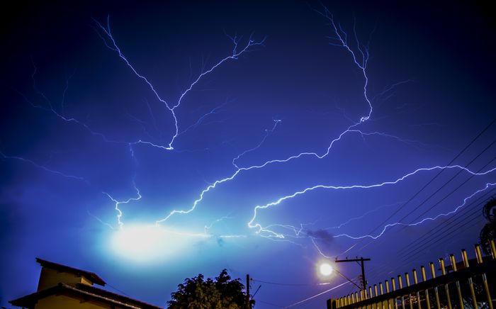 Capturing a vivid lightning storm illuminating a nighttime urban scene