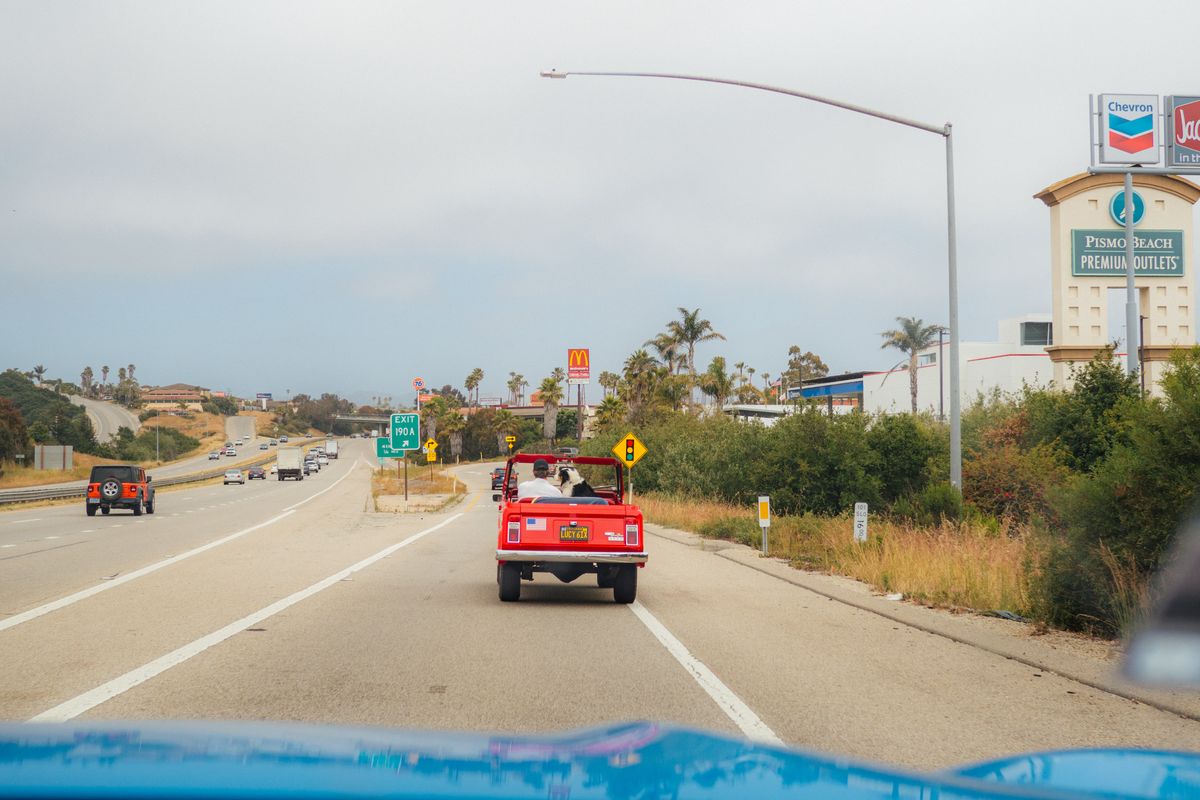 A red convertible drives along Pismo Beach Highway