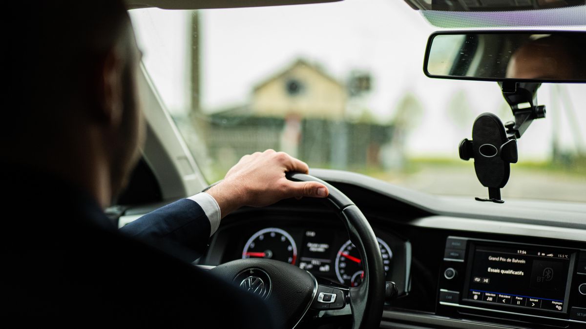Businessman in suit driving car on rainy day