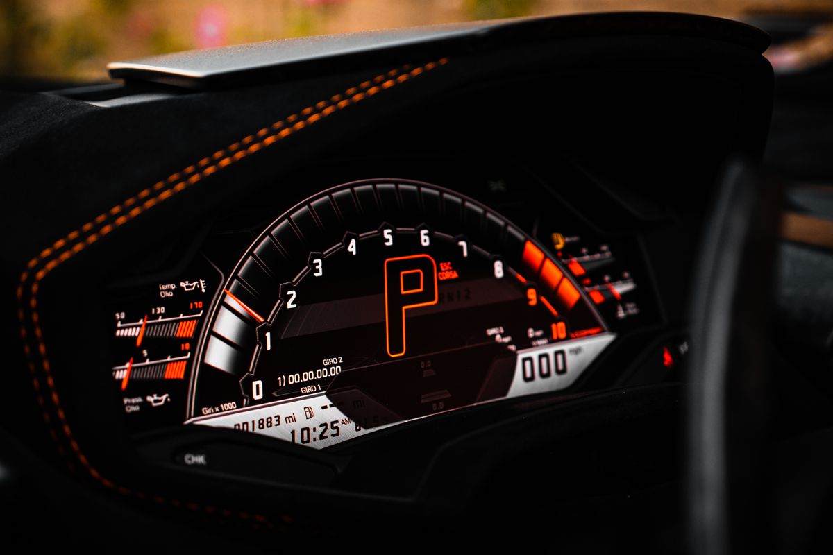 Close-up of a luxury car dashboard with digital speedometer and odometer