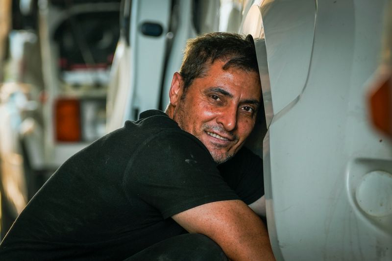 A smiling mechanic performing repairs