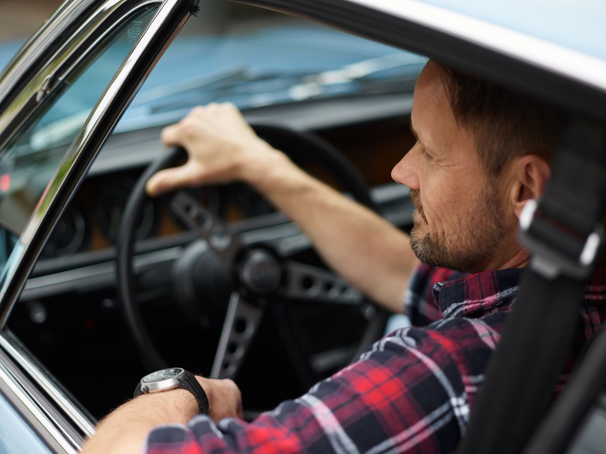 Bearded man in plaid shirt in car