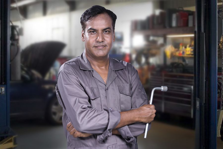 A mechanic holding a lug wrench in an auto repair shop