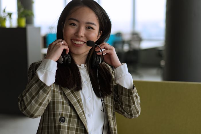 Confident woman using a headset and smiling in a modern office setting