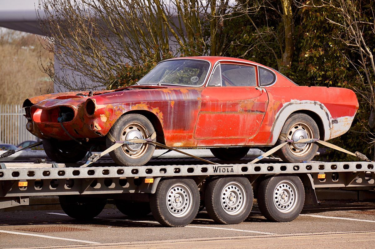 A worn-out, rusty vintage car secured